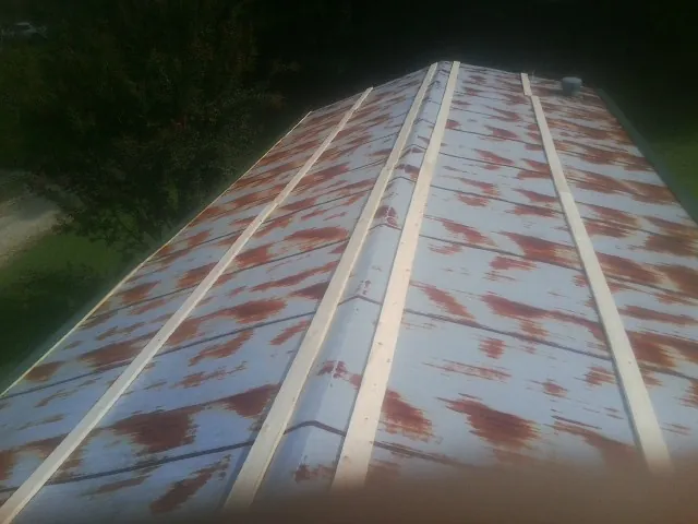 Rusted metal roof panels with new wood purlins before replacement — Storm Damage Roof Repair in Apex by Roofing Brothers
