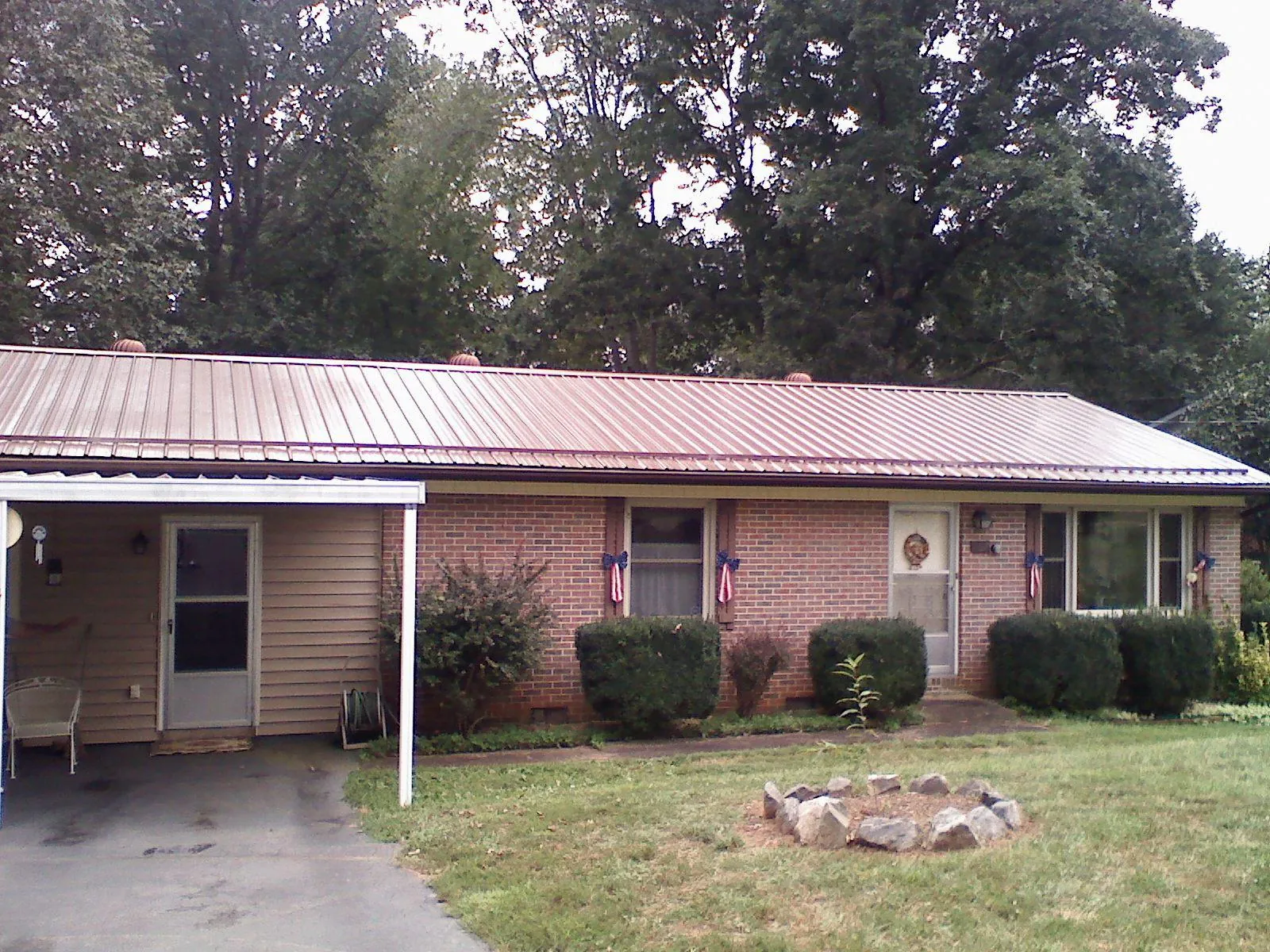 Bronze metal roof and carport on a brick ranch home — Roof Repair work by our crew in Apex
